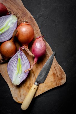 Koyu arkaplanda taze kırmızı ve beyaz soğan. Vejetaryen yemeği. Yiyecek.