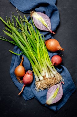 Koyu arkaplanda taze kırmızı ve beyaz soğan. Vejetaryen yemeği. Yiyecek.