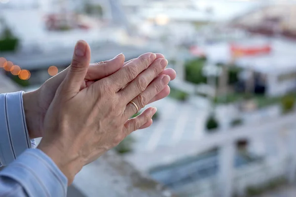 woman\'s hands on the balcony to applaud medical staff for the fight against the coronavirus. Applauding all the people who fight against covid-19. Quarantine