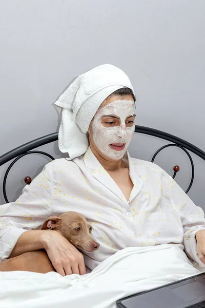 Mujer Madura Cuidando Cara Con Una Mascarilla Cama Con Perro —  Fotos de Stock