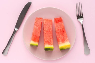 Pembe arka planda taze karpuz. Dümdüz yatıyordu. Vejetaryen gıda konsepti. Sağlıklı yiyecekler. İzole edilmiş