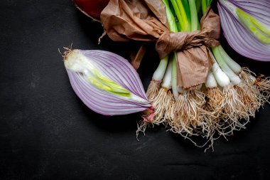 Koyu arkaplanda taze kırmızı ve beyaz soğan. Vejetaryen yemeği. Yiyecek.