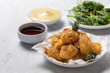 Kızarmış küçük peynirli mozzarella topları baharat, hardal sosu, soya sosu, ıspanak, kekik....
