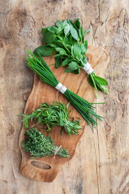 Eski ahşap arka planda yukarıdan taze aromatik bitkiler. Maydanoz, nane, kekik, fesleğen, Oregano, biberiye, soğan ve estragon.