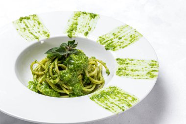Ev yapımı pesto soslu spagetti ve beyaz arka planda keklik otu. İtalyan yemeği.