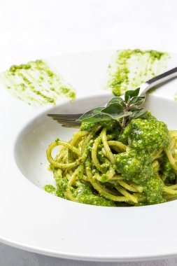 Ev yapımı pesto soslu spagetti ve beyaz arka planda keklik otu. İtalyan yemeği.
