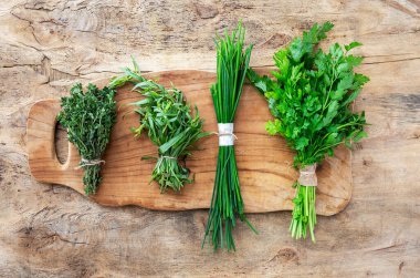 Eski ahşap arka planda yukarıdan taze aromatik bitkiler. Maydanoz, nane, kekik, fesleğen, Oregano, biberiye, soğan ve estragon.