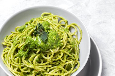 Ev yapımı pesto soslu spagetti ve gri arka planda kekik otu. İtalyan yemeği.