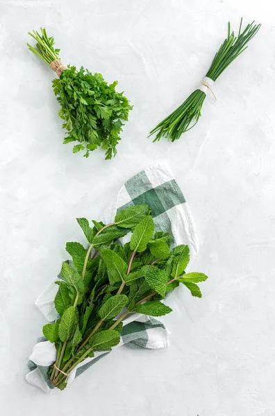 Assortment of fresh aromatic herbs from above on white background. Parsley, Mint, Thyme, Basil, Oregano, Rosemary, Chives and estragon.Flat lay.Top view