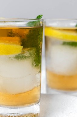 Beyaz masada buzlu, naneli ve limonlu çay bardaklarını tazeliyorum.