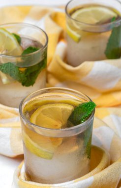 Beyaz masada buzlu, naneli ve limonlu çay bardaklarını tazeliyorum.