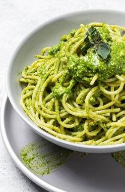 Ev yapımı pesto soslu spagetti ve gri arka planda kekik otu. İtalyan yemeği.
