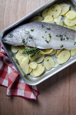 Patates, kekik ve limonla kızartılmaya hazır taze çiğ Corvina balığı. Deniz ürünleri. Corvin. Ev yapımı.