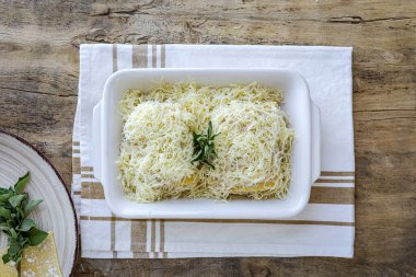 Geleneksel ev yapımı İtalyan deniz ürünleri ve peynirli lazanyayı eski ahşap arka planda hazırlayan eller. Yemek tarifi. İtalyan yemeği.