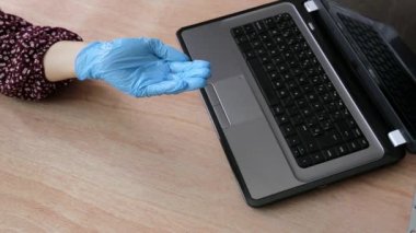 COVID-19. Çalışma masasında dizüstü bilgisayarlı hidrojeli ellerin dezenfekte edilmesi. Koronavirüs salgını