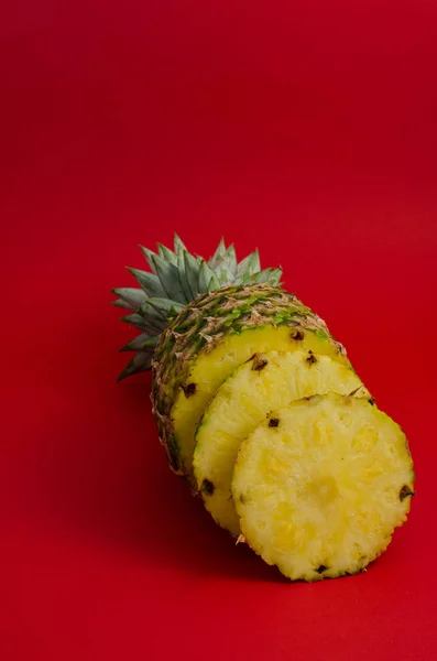 Szeletelt gyümölcs ananász, piros háttér — Stock Fotó
