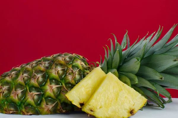Szeletelt gyümölcs ananász, piros háttér — Stock Fotó
