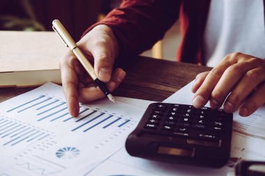 Sayıları hesaplamak için hesap makinesiyle çalışan Asyalı bir adam. Masraflar, hesap makinesi, ödemeler, kağıt notlar, ödeme masası. Finansal ve Kurulum Ödeme Konsepti. Konsept kaydediliyor - Resim