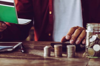 Sayıları hesaplamak için hesap makinesiyle çalışan Asyalı bir adam. Masraflar, hesap makinesi, ödemeler, kağıt notlar, ödeme masası. Finansal ve Kurulum Ödeme Konsepti. Konsept kaydediliyor - Resim