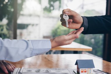 Emlakçı, kontrat imzaladıktan sonra müşterisinin ev anahtarını tutuyor. Gayrimenkul konsepti, eve taşınma ya da kiralık ev.