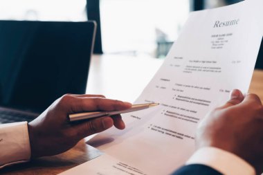 İş adamı ya da İnsan Kaynakları Müdürü tahtadan masasında özgeçmiş bilgilerini inceliyor. İstihdam ve adam toplama konsepti