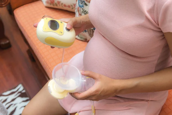Wanita hamil belajar bagaimana menggunakan pompa payudara listrik — Stok Foto