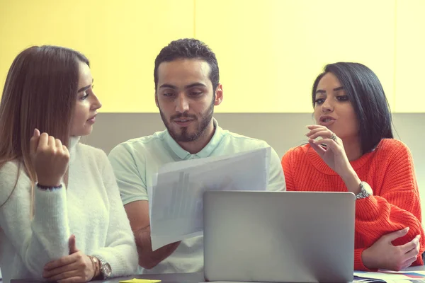 Equipo de negocios en el trabajo. Grupo de jóvenes empresarios confiados discutiendo el proyecto mientras pasan tiempo en la oficina — Foto de Stock