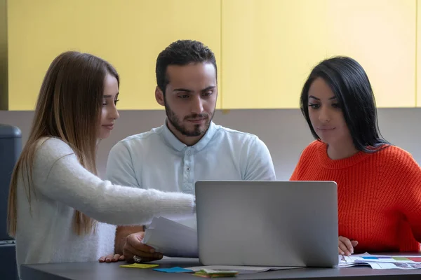 Equipo de negocios en el trabajo. Grupo de jóvenes empresarios confiados discutiendo el proyecto mientras pasan tiempo en la oficina — Foto de Stock