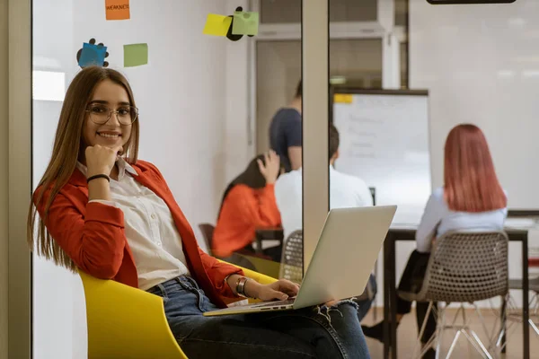 Menina ouvindo música no laptop como ela faz uma pausa do trabalho duro no espaço de co-trabalho . — Fotografia de Stock