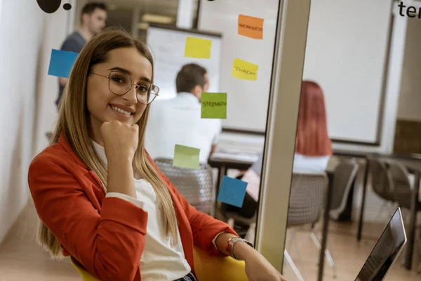 Girl listening to music on laptop as she takes a break from hard work in coworking space.