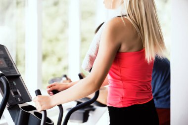 Spor salonunda ter havlu ile silerek egzersiz bisikleti üzerinde uygun kadın