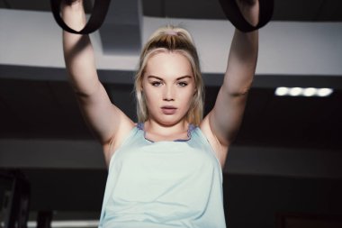 Sportif kadın spor salonunda trx egzersizleri yapıyor