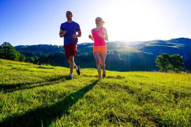 Açık havada spor yapan bir kaç fitness koşucusu. Aktif yaşayan erkek ve kadın yazın doğa antremanında koşu yapıyorlar..