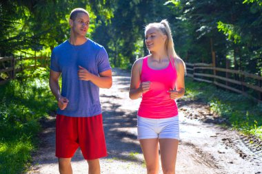 Açık havada spor yapan bir kaç fitness koşucusu. Aktif yaşayan erkek ve kadın yazın doğa antremanında koşu yapıyorlar..