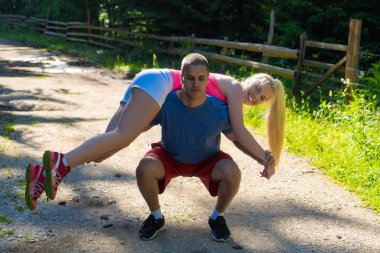 Genç spor çifti ormanda egzersiz yapıyor.