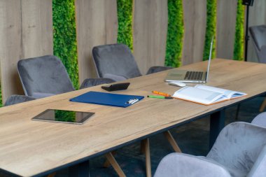 Üniversite öğrencileri, kitaplar ve dizüstü bilgisayarlarla aynı masada oturuyorlar. Üniversite kütüphanesinde bir grup çok ırklı insan..