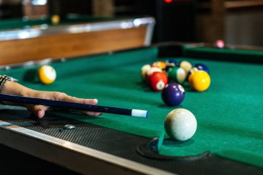 Sports game of billiards on a green cloth. Billiard balls with numbers on a pool table. Billiards team sport.