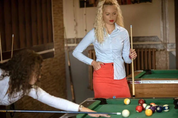 Mulheres sorridentes bonitas jogando bilhar em um bar — Fotografia de Stock