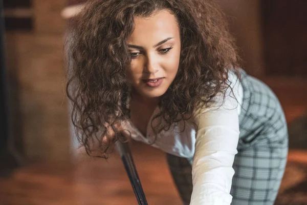 Beautiful smiling women playing billiards at a bar