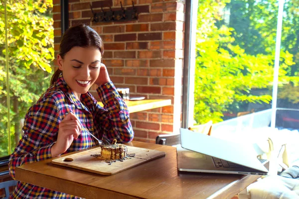 Jovem mulher feliz atraente sentado e comendo sobremesa no café — Fotografia de Stock