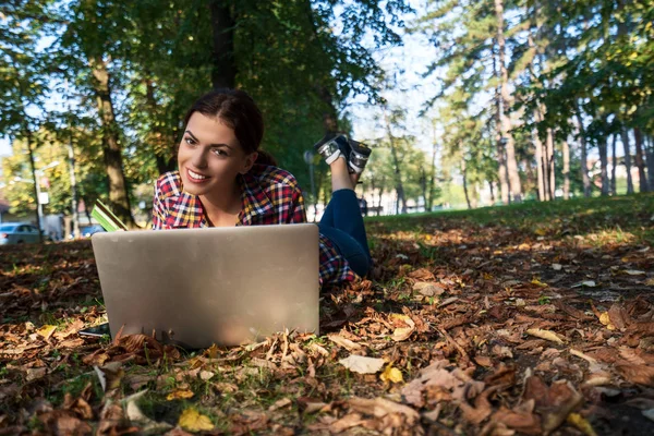 happy women in park using laptop and bank card.Online shopping