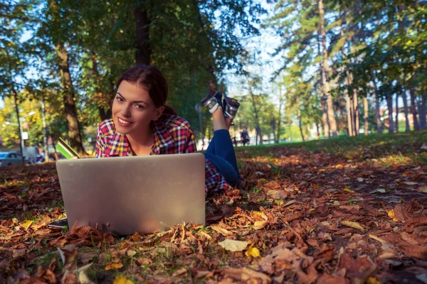Mujeres felices en el parque usando el ordenador portátil y tarjeta bancaria.Compras en línea — Foto de Stock