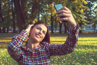 Selfie zamanı. Güzel genç kız parkta selfie çekiyor..