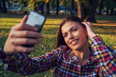 Selfie zamanı. Güzel genç kız parkta selfie çekiyor..