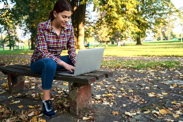Feliz hipster joven mujer trabajando en el ordenador portátil en el parque — Foto de Stock