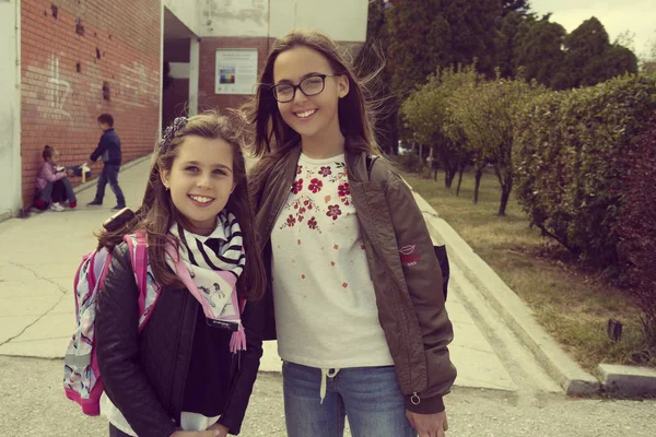 L'éducation primaire, l'amitié, l'enfance et les gens concept - groupe d'élèves heureux de l'école primaire avec sacs à dos marchant à l'extérieur de dos - Image — Photo