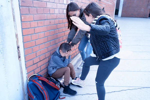 Schoolyard bullies, concept of this taking place after school,Aggressive teenagers bullying boy outdoors. - Image — Stock Photo, Image