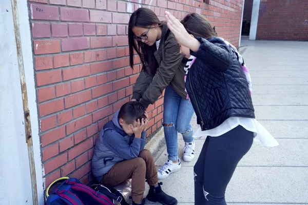 Schoolyard bullies, concept of this taking place after school,Aggressive teenagers bullying boy outdoors. - Image — Stock Photo, Image