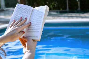 Bilardoda kitap okuyan genç bir kadın