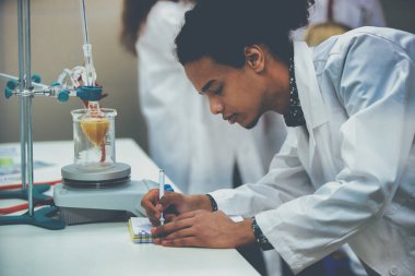 Laboratuvarda deney tüpüyle çalışan çok kültürlü bilim adamları.